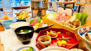 Kurobe Sunvalley Hotel في أوماتشي: طاولة مليئة بأنواع مختلفة من الطعام عليها