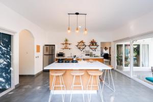 a kitchen with a white counter and stools at Secret Haven Cozy 3 Bedroom Private Pool Villa in Gili Trawangan