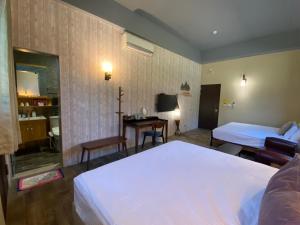 um quarto de hotel com duas camas e uma secretária em Starry Night em Taitung City