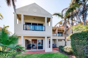 a house with palm trees in front of it at Waterfront Townhouse - One in Port Lincoln