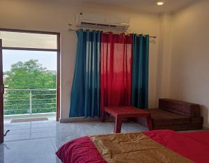 a bedroom with colorful curtains and a sliding glass door at Hide and Seek by StayApart in Dehradun