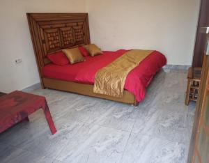 a bedroom with a large bed with red sheets at Hide and Seek by StayApart in Dehradun