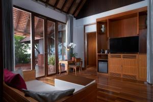 a living room with a couch and a television at Renaissance Koh Samui Resort & Spa in Lamai