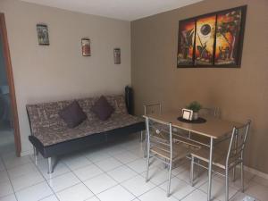 ein Wohnzimmer mit einem Sofa und einem Tisch in der Unterkunft Agradable y cómodo departamento a 5 minutos del aeropuerto in Mexiko-Stadt