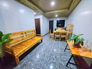 sala de estar con bancos de madera y mesa en TLShaw Homestay, en General Luna