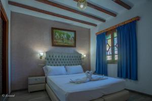 - une chambre avec un grand lit blanc et des rideaux bleus dans l'établissement Guest House Yasmina, à Chefchaouen