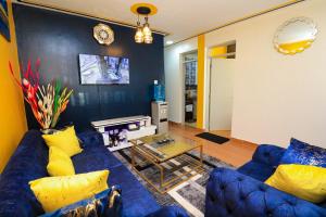 a living room with a blue couch and yellow pillows at Joy fully furnished & serviced apartments in Kiambu