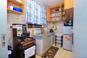 a small kitchen with a stove and a refrigerator at Joy fully furnished & serviced apartments in Kiambu