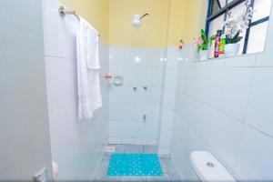 a bathroom with a shower with a blue mat on the floor at Joy fully furnished & serviced apartments in Kiambu +12 photos