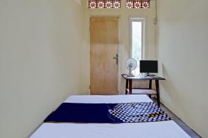een slaapkamer met een bed in een kamer met een deur bij SPOT ON 92799 Tanjung Indah Homestay Syariah in Banyuwangi