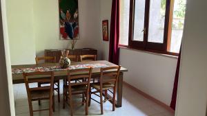 a dining room with a wooden table and chairs at Il GIARDINO della FALENA in Favignana