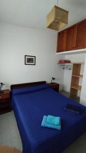um quarto com uma cama azul com lençóis azuis em Cafayate Central House em Cafayate
