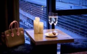 - une table avec un verre de vin à côté d'une fenêtre dans l'établissement Daiwa Roynet Hotel Kyoto Terrace Hachijo PREMIER - former Daiwa Roynet Hotel Kyoto Terrace Hachijohigashiguchi, à Kyoto