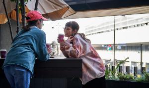 una mujer hablando con una mujer en una mesa en Daiwa Roynet Hotel Kyoto Terrace Hachijo PREMIER - former Daiwa Roynet Hotel Kyoto Terrace Hachijohigashiguchi, en Kioto