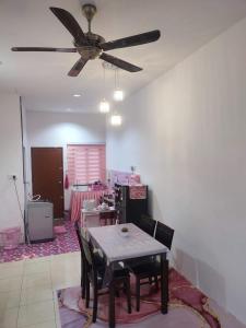 a dining room with a table and a ceiling fan at Wan K Homestay Gua Musang in Gua Musang