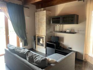 een woonkamer met een bank en een open haard bij La scalinata del Borgo in Montecorvino Rovella