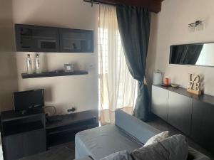 sala de estar con sofá y TV en La scalinata del Borgo, en Montecorvino Rovella