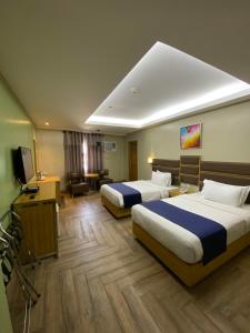 um quarto de hotel com duas camas e uma televisão em Sun Star Grand Hotel em Manila