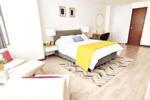 a bedroom with a large bed with a yellow blanket at Rivera MaiaHome-Hermoso apt en Polanco cerca Antara - 2BR 2BT in Mexico City