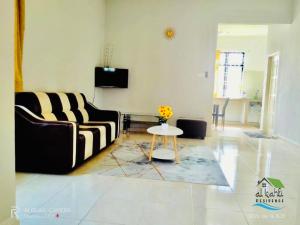 a living room with a couch and a table at Qalya Homestay 2 @ Kota Bharu in Kota Bharu +3 photos