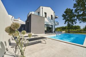 a house with a swimming pool in front of it at Villa Barbara in Poreč