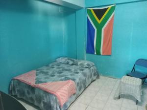 a blue room with a bed and a flag at Save's Homestay in Nadi