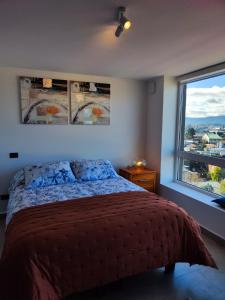 Departamento Centro de Valdivia, Caupolican في فالديفيا: غرفة نوم بسرير ونافذة كبيرة