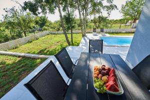 a plate of fruit on a table next to a pool at Villa Barbara in Poreč