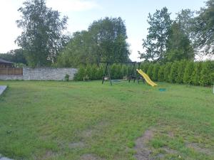 a playground with a yellow slide in a yard at Rukkilille majutus in Herjava