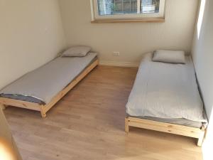 Duas camas num pequeno quarto com pisos em madeira em Rukkilille majutus em Herjava