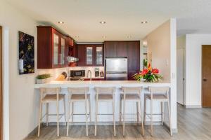 Una cocina con una gran isla con taburetes de bar. en Waikoloa Villas A107, en Waikoloa