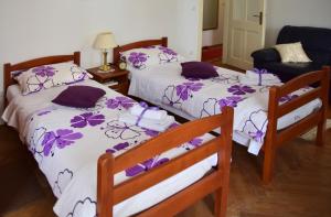 two beds in a room with purple flowers on them at Apartment Dona Vesna in Dubrovnik
