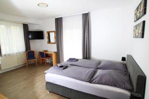 a bedroom with a bed and a table and chairs at Hotel Sonnenhof in Sindelfingen