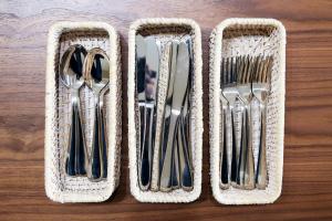 three baskets of cutlery sitting on a wooden table at Meteor Shower in Sapporo