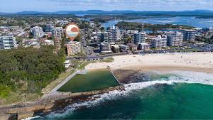 an aerial view of a beach and a city at Beachpoint Unit 501 in Forster