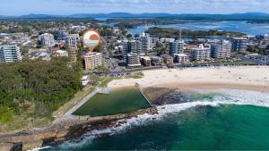 an aerial view of a beach and a city at Beachpoint, 401 in Forster