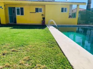 una casa gialla con una piscina di fronte di Hermosa casa de descanso, alberca privada, caldera a Oaxtepec