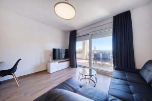 a living room with a blue couch and a television at Vidalis, no 1 in Kožino