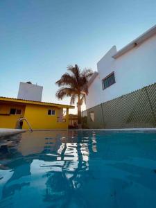 uma piscina em frente a uma casa com uma palmeira em Hermosa casa de descanso, alberca privada, caldera em Oaxtepec