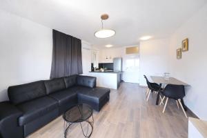 a living room with a black couch and a table at Vidalis, no 1 in Kožino