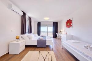 a white room with two beds and a table at Vidalis, no 1 in Kožino +10 photos