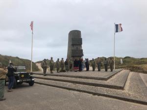 un grupo de soldados parados frente a un monumento en chambre d'hôtes Le Domaine de la Vallée en Saint-Martin-de-Varreville