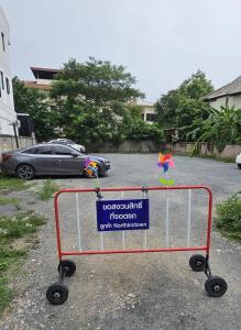 a shopping cart with a sign on it in a parking lot at North Inn Town Chiangmai in Chiang Mai
