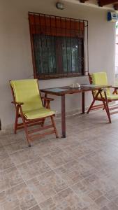 two chairs and a wooden table with a table and two chairs at Eleni's house in Karianí