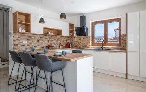 a kitchen with a table and some chairs in it at 3 Bedroom Nice Home In Kavran in Kavran