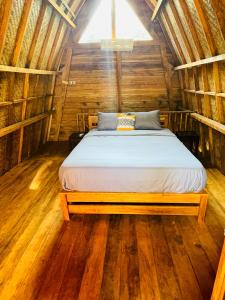 - une chambre avec un lit dans une cabane en bois dans l'établissement SAJA Cottage, Gili Meno, à Gili Meno