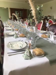uma mesa longa com pratos de comida e copos de vinho em chambre d'hôtes Le Domaine de la Vallée em Saint-Martin-de-Varreville