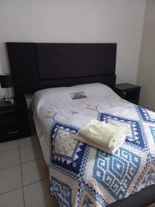 ein Bett mit einer Decke und zwei Handtüchern darauf in der Unterkunft Nice apartamento. 5 minutos del aeropuerto. in Mexiko-Stadt