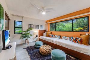 Una sala de estar con una cama grande y un televisor. en Waikoloa Villas A107, en Waikoloa