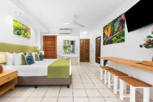 a hotel room with a bed and a bathroom at Palm Cove Treetop Spa Retreat in Palm Cove